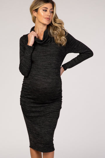 woman wearing a black cowl neck maternity dress with ruching, highlighting her baby bump