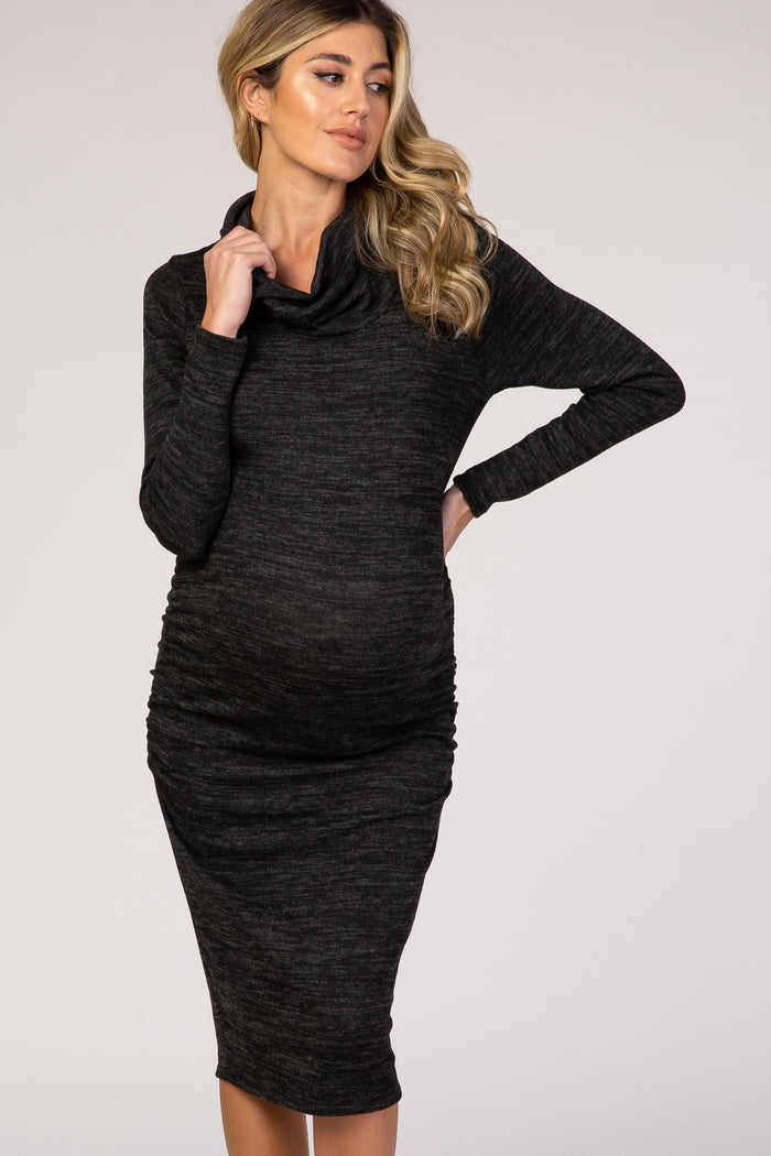 woman wearing a black cowl neck maternity dress with ruching, highlighting her baby bump