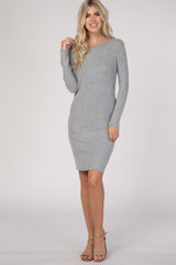 woman wearing a light gray long sleeve sweater dress with a fitted silhouette and a round neckline