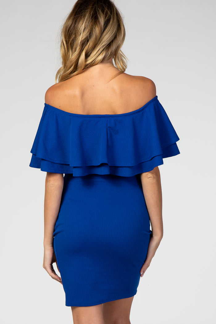 woman wearing a royal blue off-the-shoulder maternity dress with layered ruffle details on the sleeves