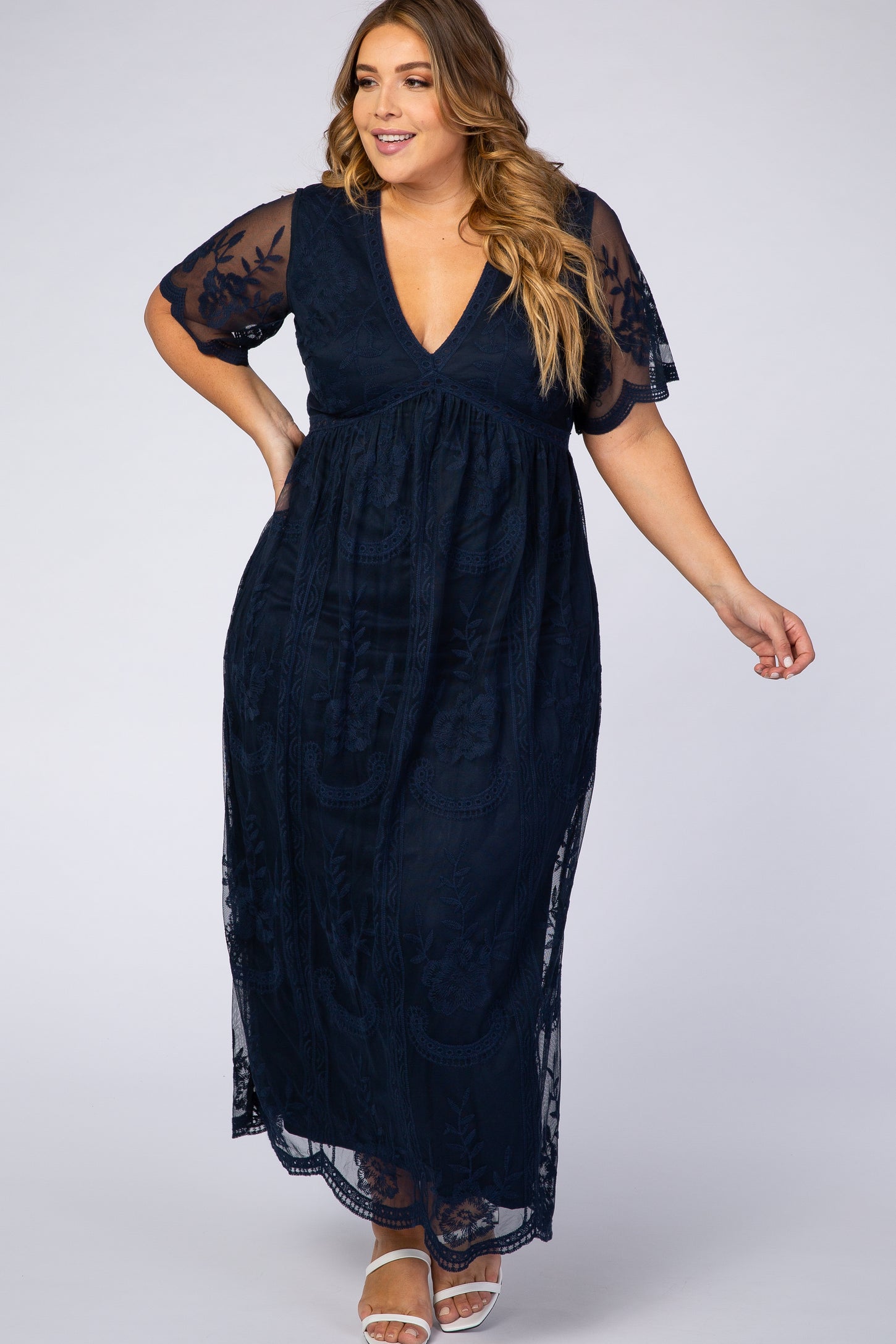 woman wearing a navy blue plus size maxi dress with short lace sleeves and a v-neckline