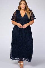 woman wearing a navy blue plus size maxi dress with sheer embroidered sleeves and a flattering v-neckline