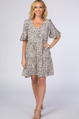 woman wearing a short beige dress with black spots and flounce sleeves