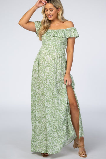 woman wearing a green floral off-the-shoulder maternity maxi dress with a thigh-high slit
