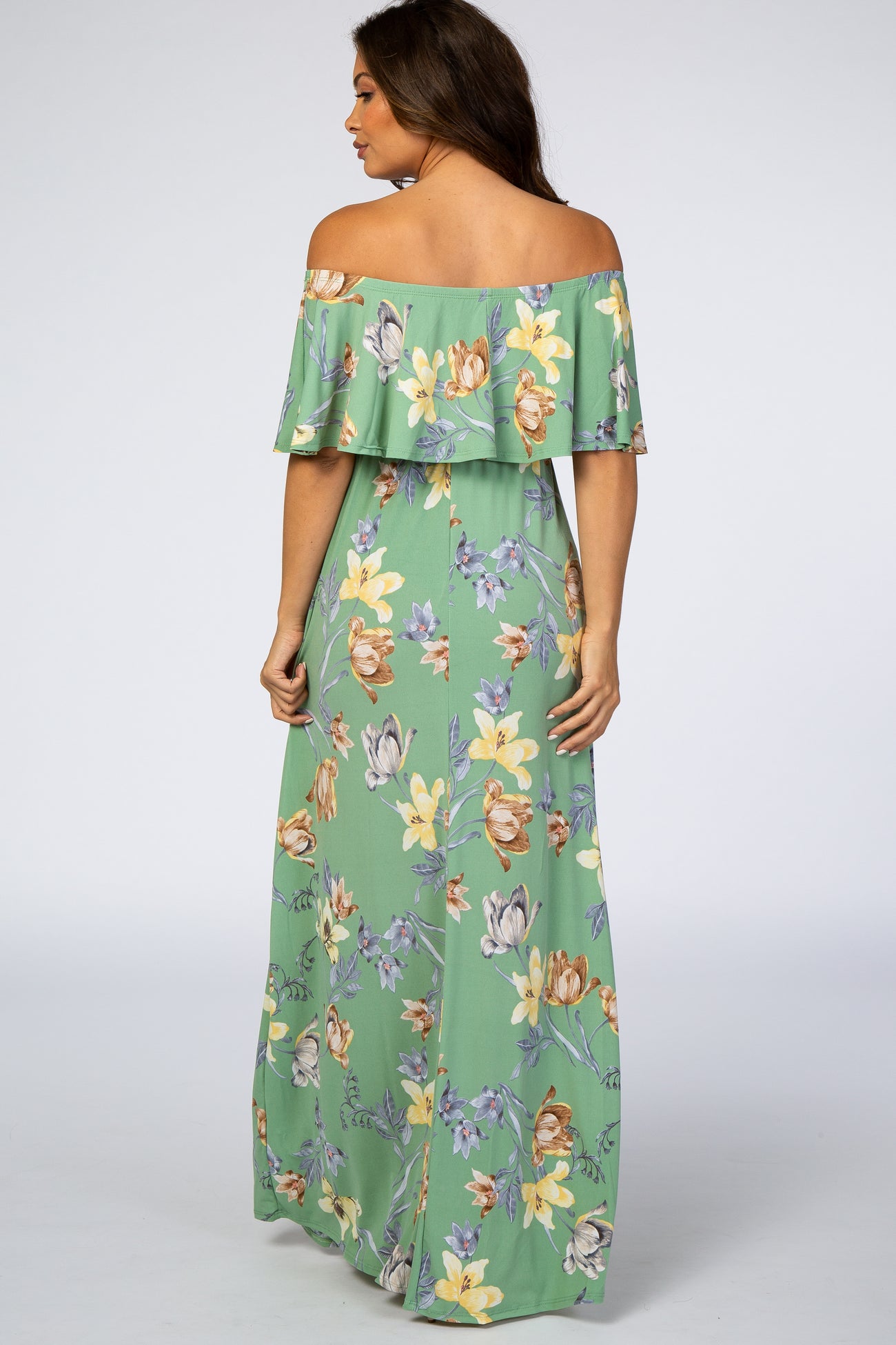 woman wearing a green floral off-the-shoulder maternity maxi dress seen from the back