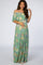 woman wearing a green floral off-the-shoulder maternity maxi dress and holding her baby bump