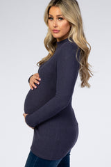 woman wearing a dark navy ribbed maternity sweater and holding her baby bump