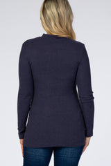 woman wearing a dark purple ribbed maternity top, showing the back view with long sleeves and a fitted style