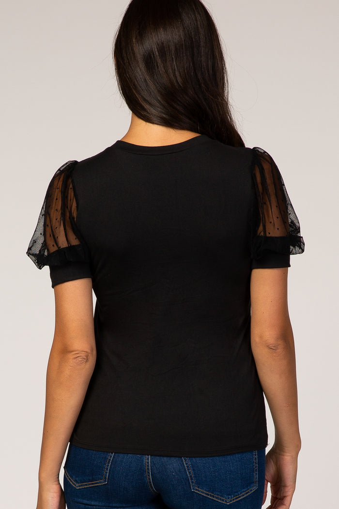 black t-shirt with sheer polka dot puff sleeves, worn by a woman facing away, styled with blue jeans