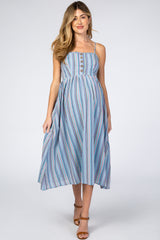 woman wearing a blue and white striped maternity dress with button details and a flowing skirt, showing her baby bump