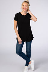 woman wearing a black short sleeve top paired with blue skinny jeans and white sneakers