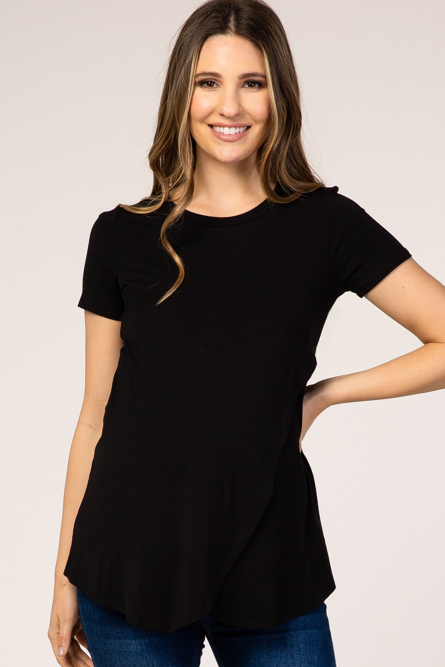 woman wearing a black short sleeve maternity top with a curved hem and relaxed fit