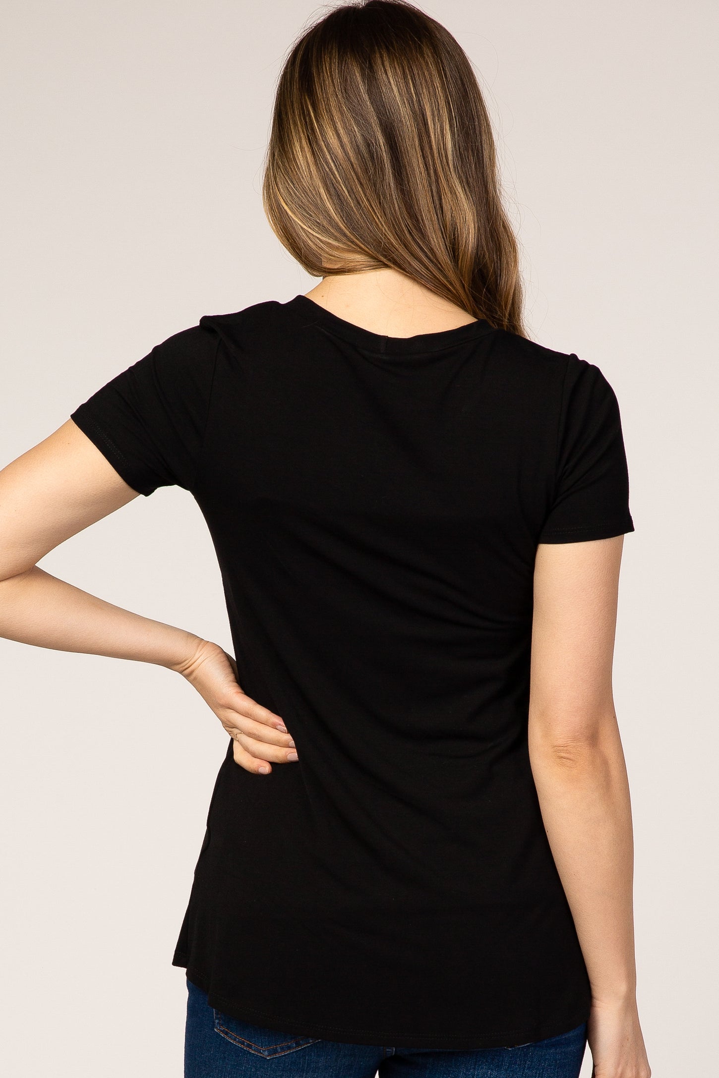 back view of a woman with long brown hair wearing a basic black short sleeve t-shirt and blue jeans