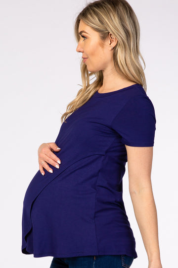 woman wearing a royal blue short sleeve maternity top, showing her baby bump