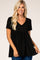 woman wearing a black short sleeve peplum top with a v-neck and textured fabric