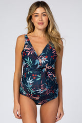 pregnant woman wearing navy blue floral maternity one piece swimsuit with front tie detail