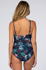 woman wearing a navy blue maternity swimsuit with a floral print and adjustable straps, showing her back