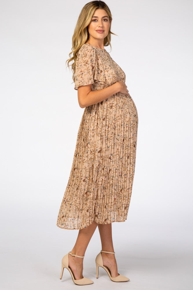 woman wearing a floral pleated maternity dress with short sleeves and a visible baby bump