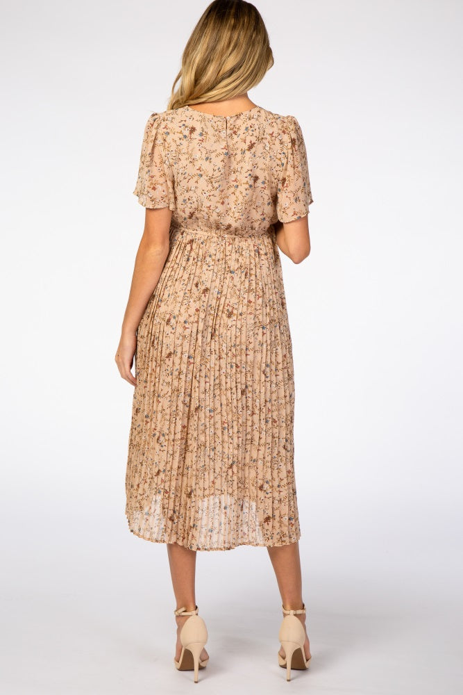 woman wearing a beige floral maternity dress with short sleeves and pleated skirt, showing her back