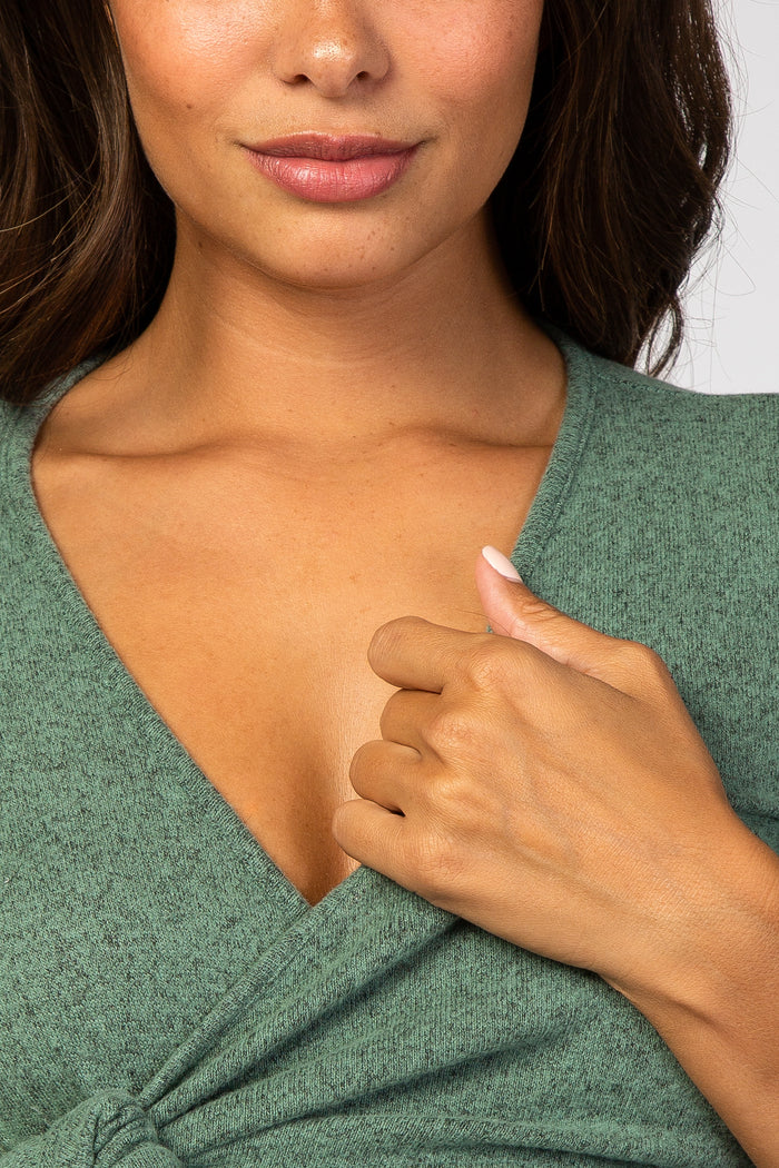 woman wearing a green v-neck maternity top with a tied knot detail at the waist