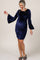 woman wearing a navy blue velvet maternity dress with bell sleeves and ruched detailing