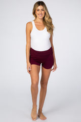 woman wearing a white tank top and burgundy maternity shorts, showcasing comfort and style for pregnant women