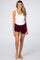 woman wearing a white tank top and burgundy maternity shorts, showcasing comfort and style for pregnant women