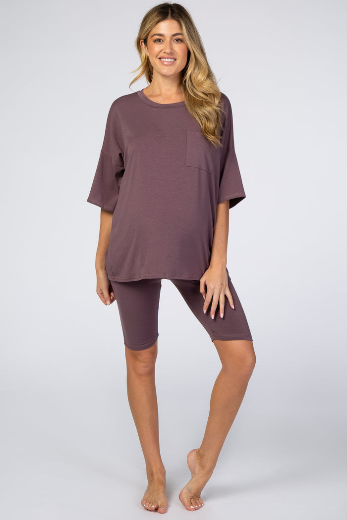 woman wearing a mauve maternity oversized t-shirt with pocket and matching bike shorts, showing her baby bump
