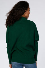 woman wearing a dark green oversized sweater with ribbed texture and long sleeves, shown from the back