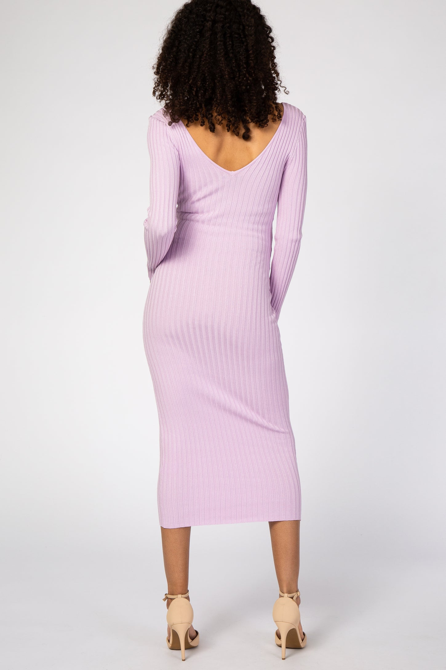 woman wearing a lilac long sleeve ribbed maternity dress with a v-back and fitted silhouette