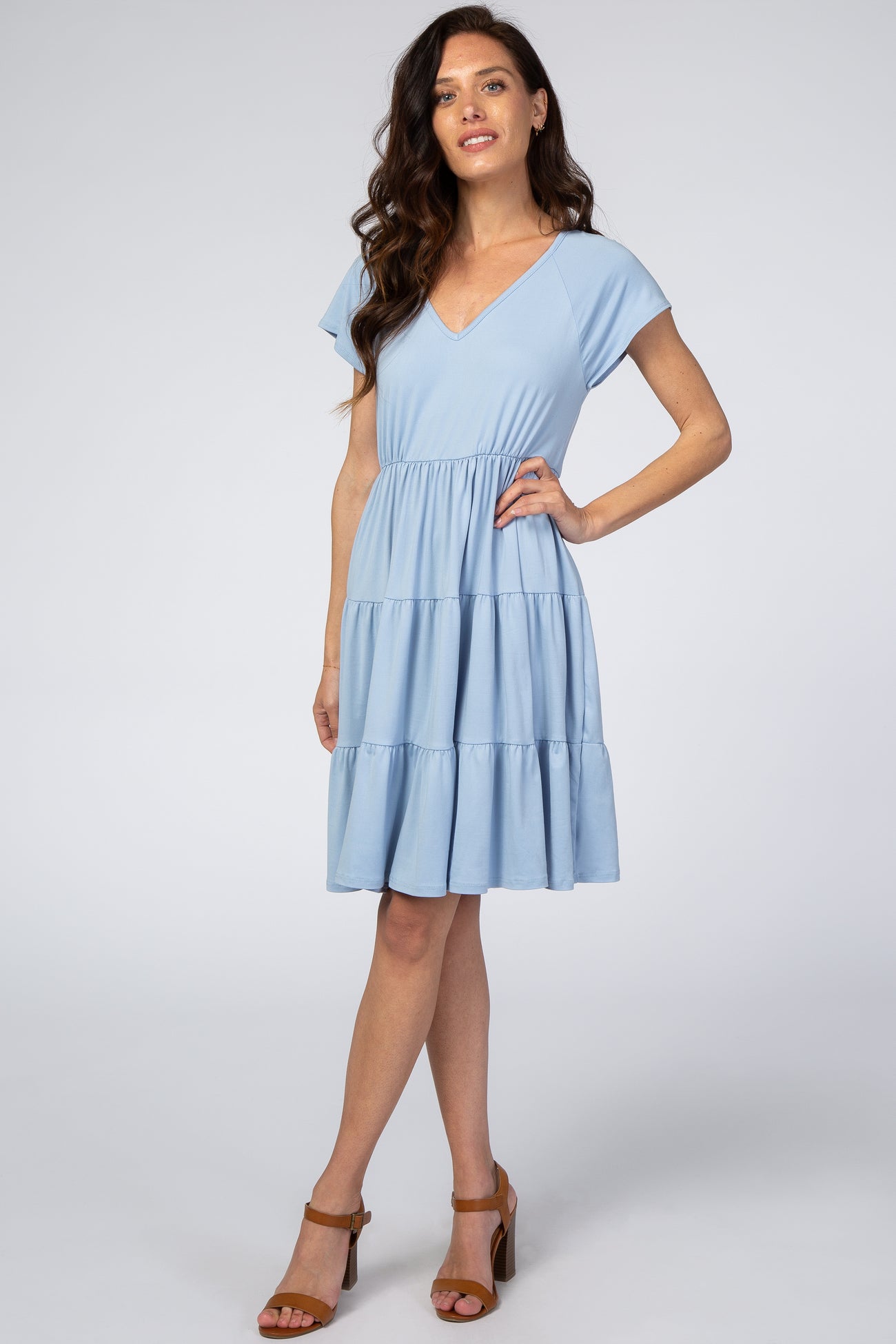 woman wearing a light blue short sleeve tiered maternity dress with brown block heel sandals
