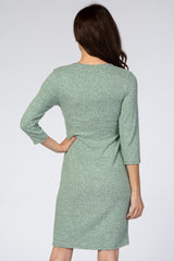 woman wearing a light green three-quarter sleeve dress, seen from the back