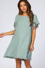 woman wearing a mint green loose-fitting maternity dress with fringe details on the sleeves
