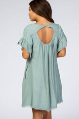 woman wearing a mint green maternity dress with flutter sleeves and an open back detail