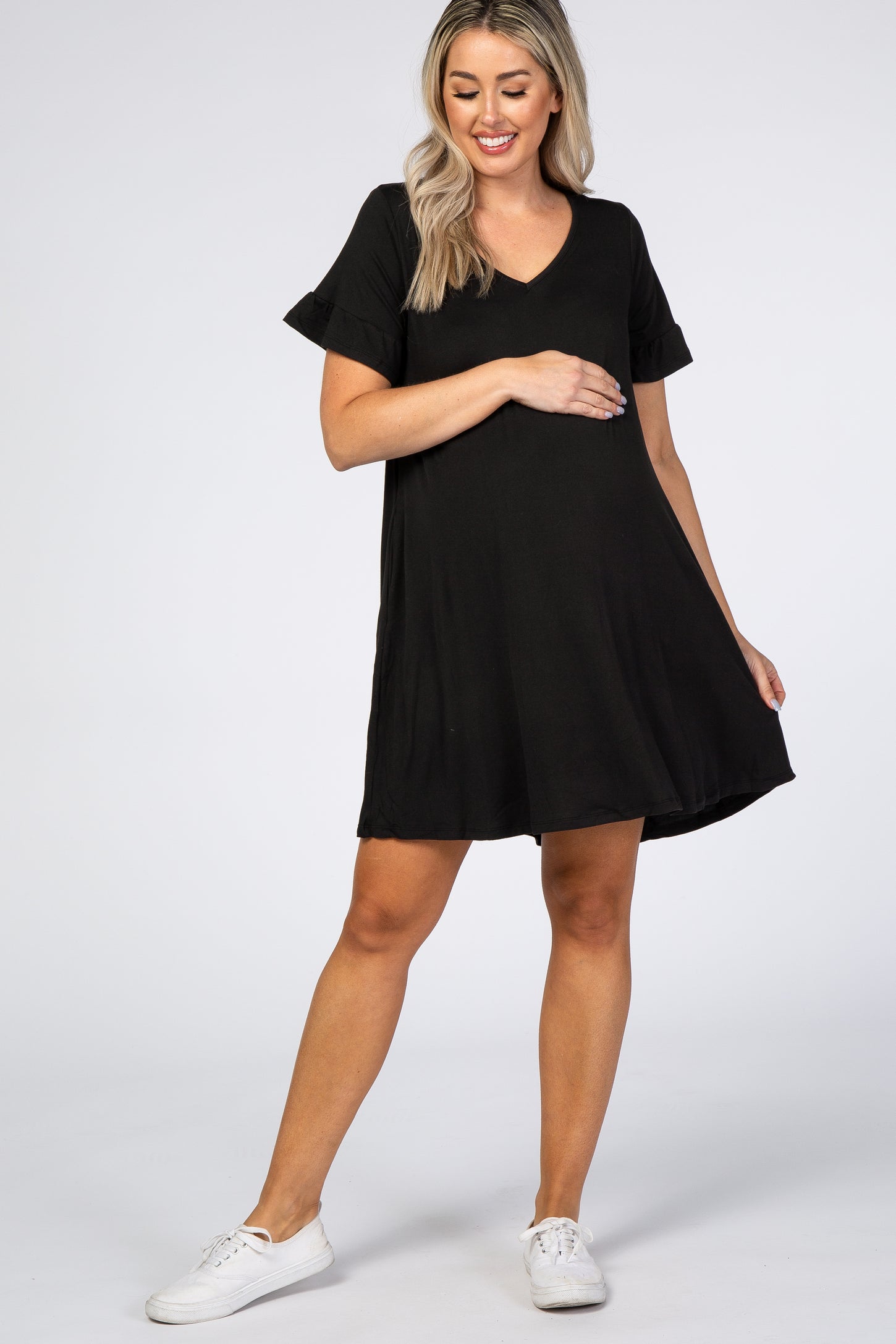 woman wearing a black short sleeve maternity dress and gently holding her baby bump