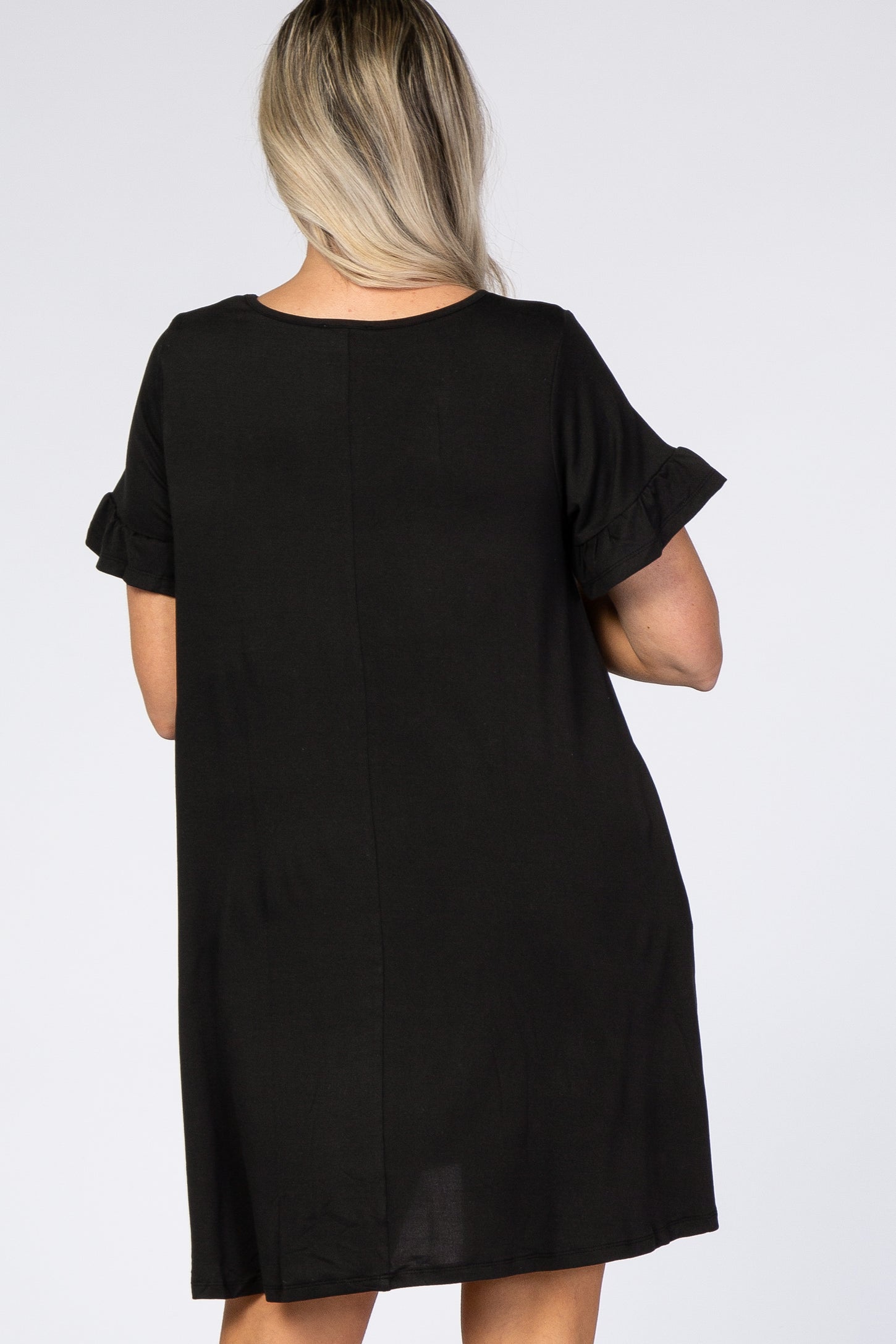 woman wearing a short sleeve black maternity dress with ruffled sleeves, showing the back view