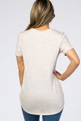 woman wearing a light beige short sleeve top with a relaxed fit and ribbed texture, showing the back view