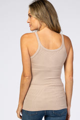 woman wearing a taupe ribbed tank top viewed from the back with long hair and blue jeans