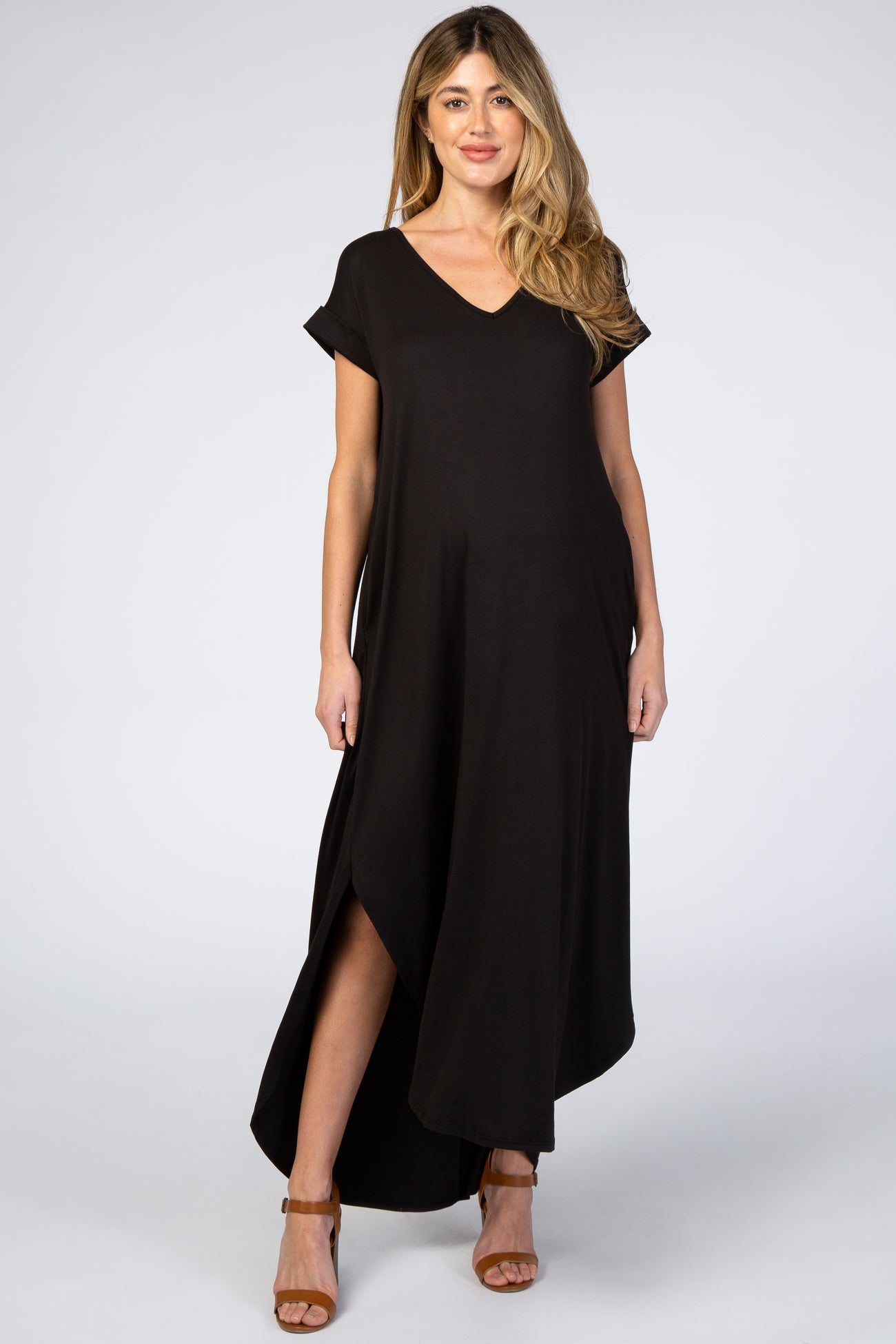 woman wearing a black short sleeve v-neck maternity maxi dress with side slits and brown sandals