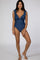 woman wearing a navy blue ruffled one-piece swimsuit with a deep v-neck and a fitted silhouette