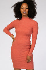 woman wearing a rust-colored ribbed long sleeve bodycon dress with a high neckline