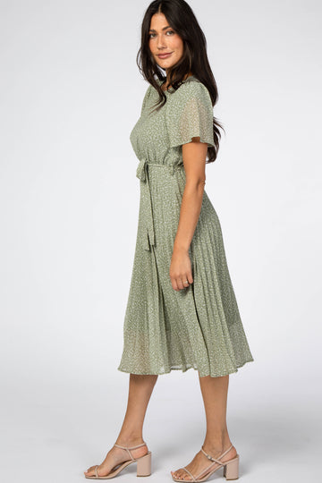 woman wearing a green floral midi dress with short sleeves and a tied waist detail