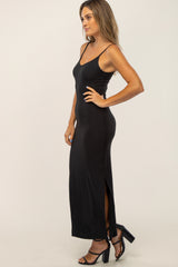woman wearing a black ribbed maxi dress with a side slit and spaghetti straps