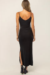back view of woman wearing black ribbed maxi dress with spaghetti straps and side slit