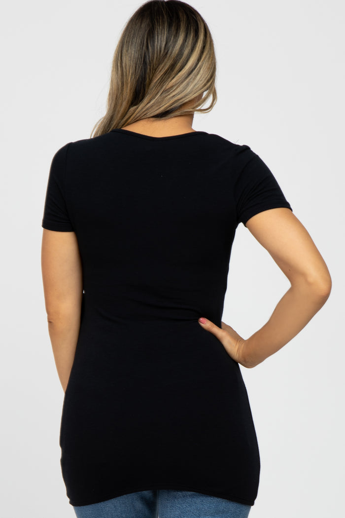 Back view of a woman wearing a fitted black short-sleeve t-shirt and blue jeans against a white background
