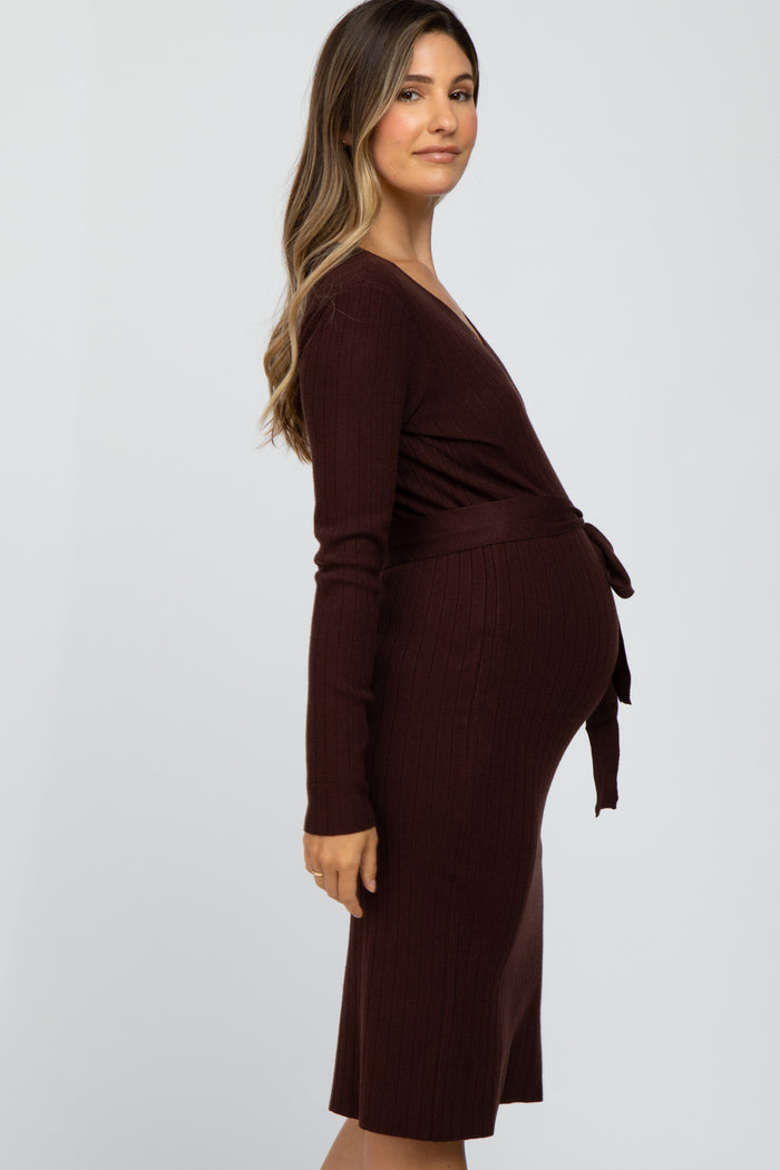 woman wearing a burgundy ribbed maternity dress with a wrap design and tied waist, showcasing her baby bump