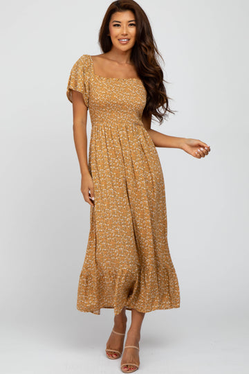 woman wearing a mustard yellow floral midi dress with short puff sleeves and a smocked bodice
