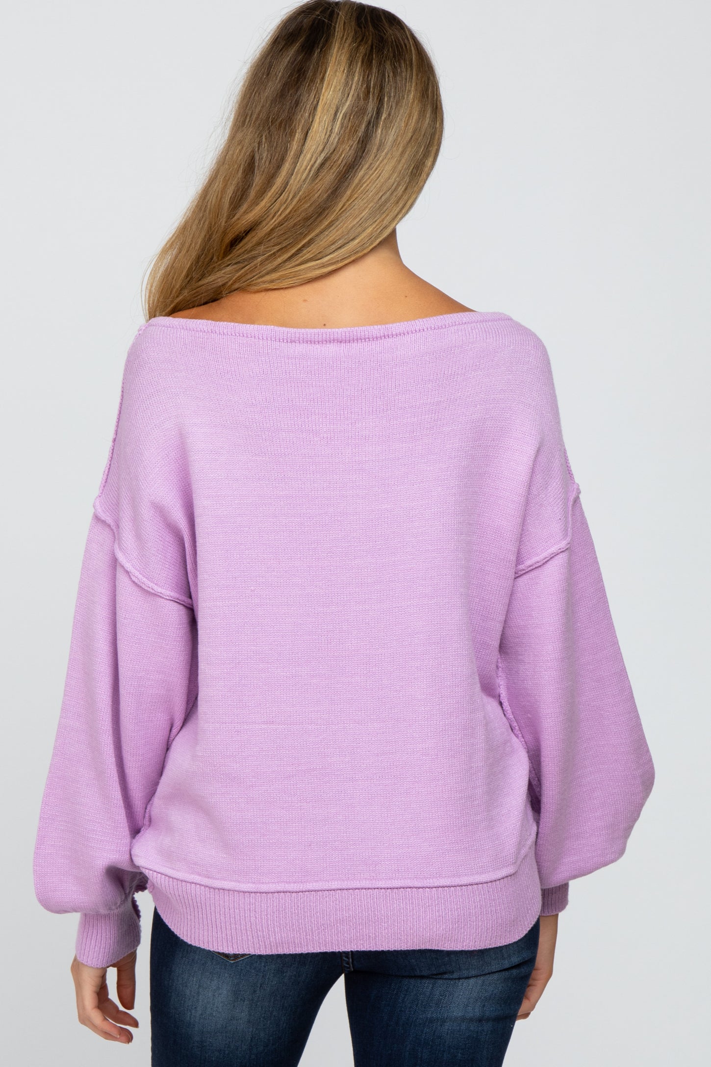woman wearing a lilac oversized maternity sweater with a relaxed fit, seen from the back