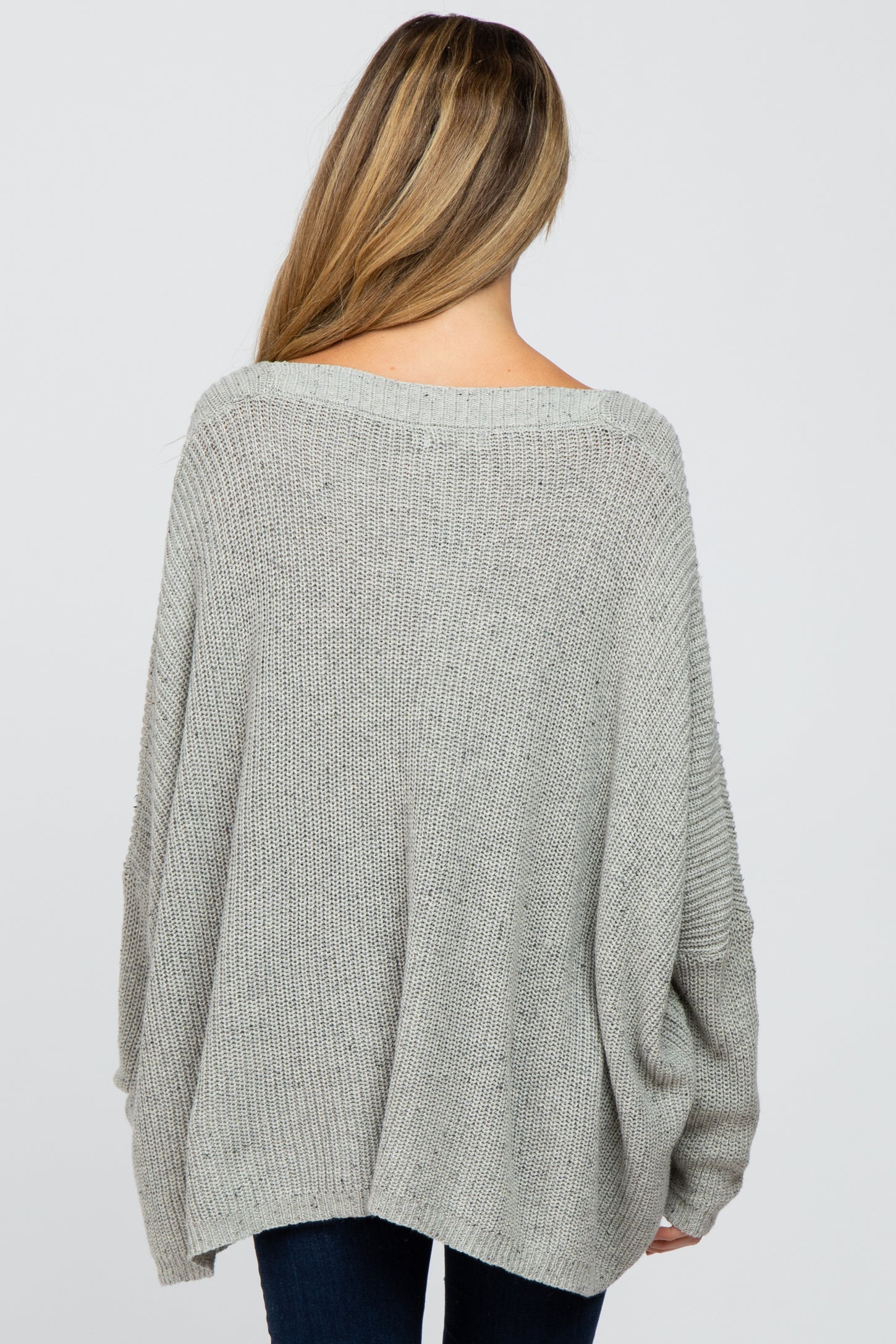 woman wearing a loose-fitting grey oversized maternity sweater viewed from the back