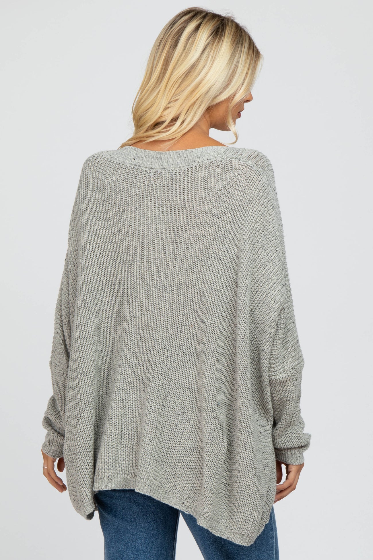 woman wearing a cozy gray oversized knit sweater with a relaxed silhouette and dropped shoulders